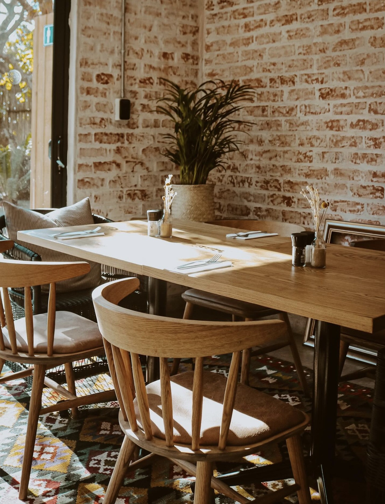 Brick corner with rattan chairs inside The Coastal Collective