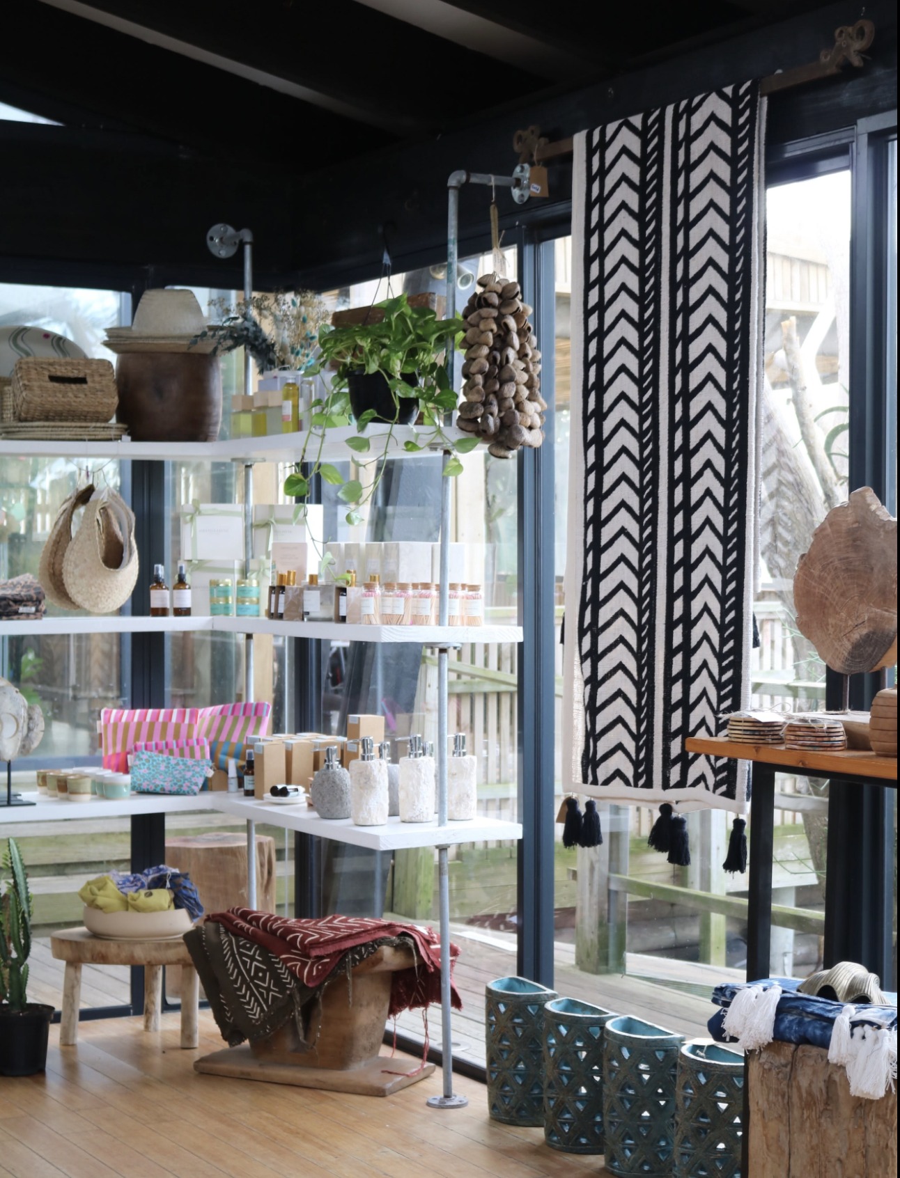 Shelves inside The Coastal Collective boutique with candles, ceramics and textiles